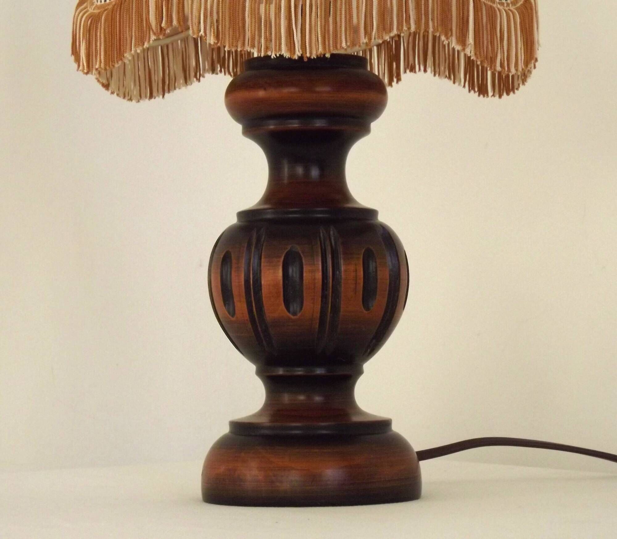 Mid-century French table lamp made of turned carved wood with a fringed shade.
