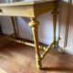 Desk table from the late 19th century, painted mustard, with turned stretcher.