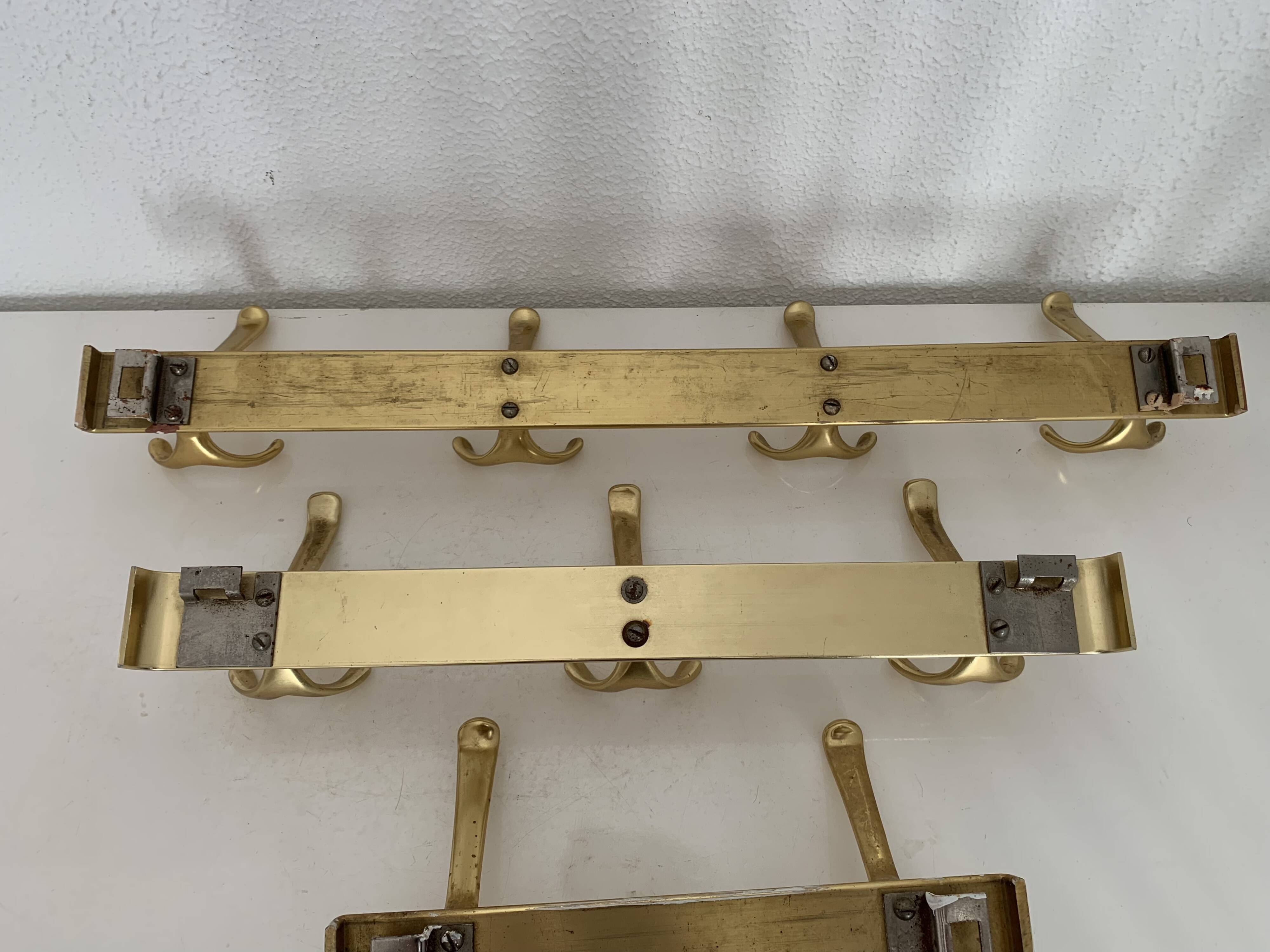 Three vintage 1960s gold coat racks with 4, 3 and 2 hooks