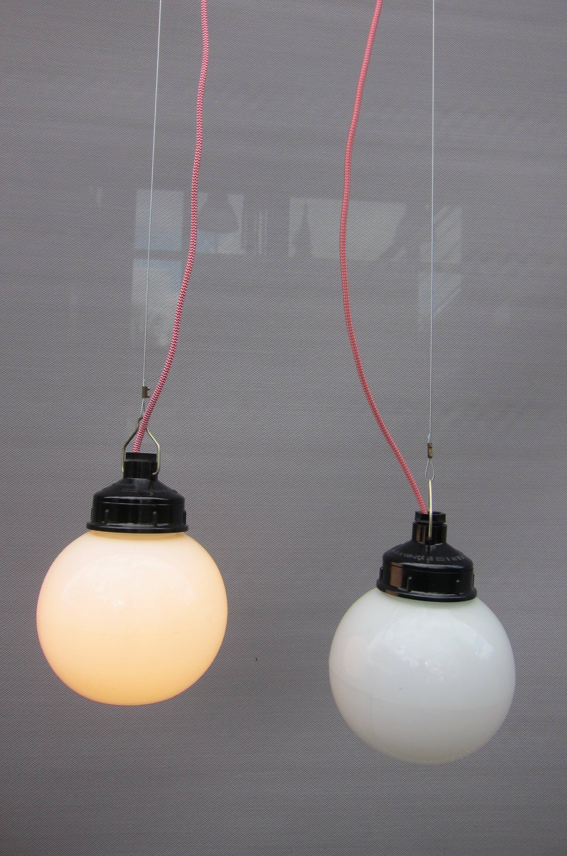 Trio of opal glass and bakelite globe pendant lights