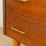 Vintage 1960s chest of drawers with covered handles.