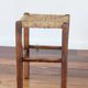 Rustic old stool made of wood and straw.
