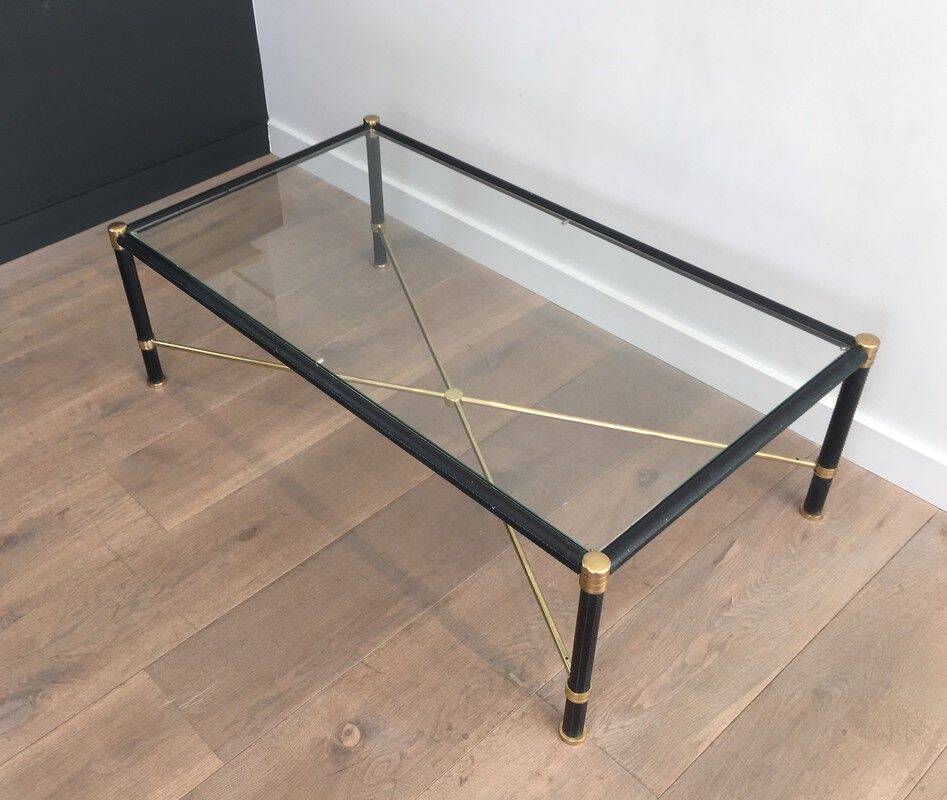 Brass coffee table upholstered in black leather. In the style of Jacques Adnet.