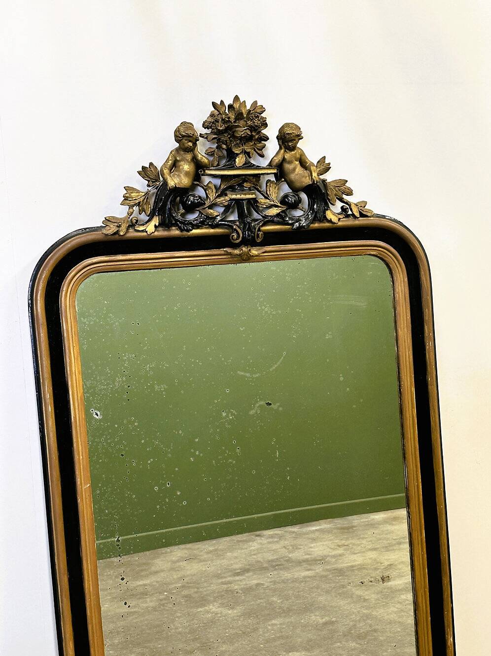 Antique 1800s black and gold mirror with cupid, France 1800s.