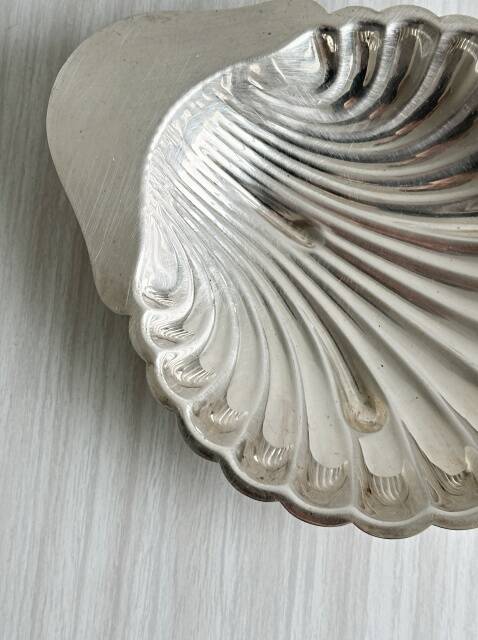 Old metal plate in the shape of a shell.