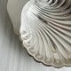 Old metal plate in the shape of a shell.