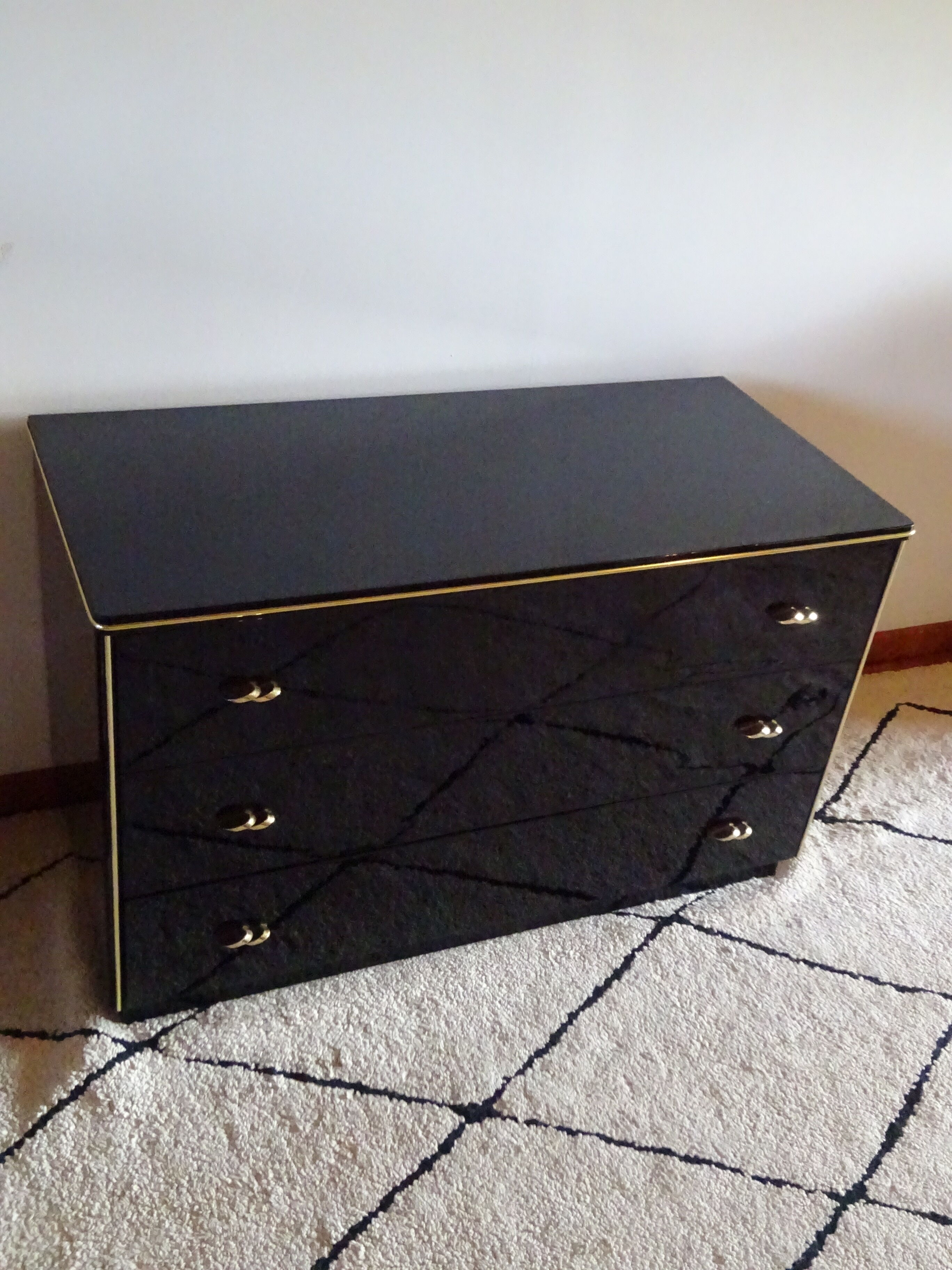 Lacquered black chest of drawers, golden brass