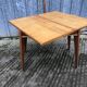 Table vintage portefeuille en chêne aux pieds compas.