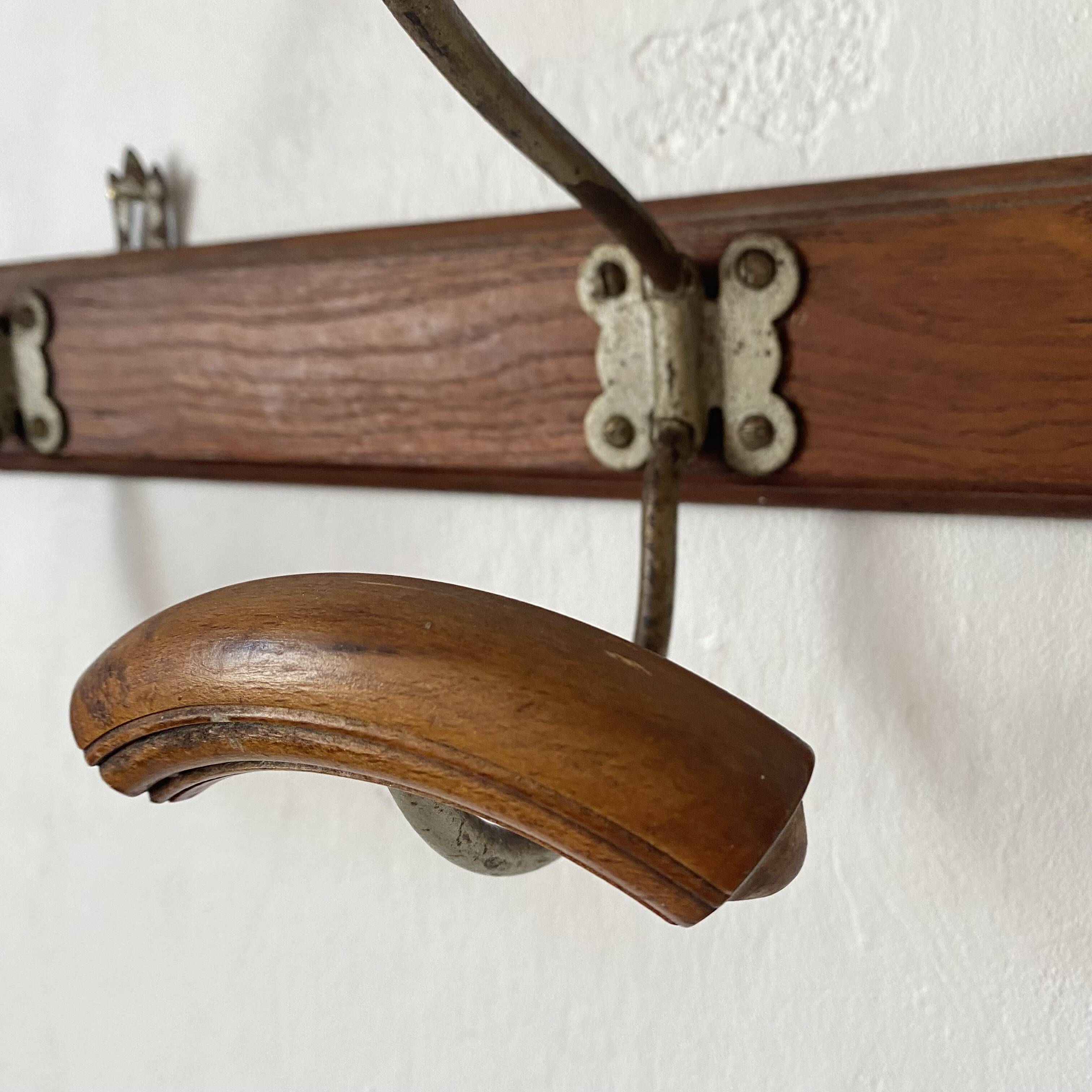 Antique wall-mounted coat rack in wood and metal