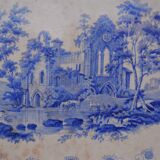 Grand plat décoratif en faïence bleue avec ruine d'abbaye début XIXe siècle.