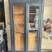 Black painted wardrobe with two glass doors and an interior sideboard.