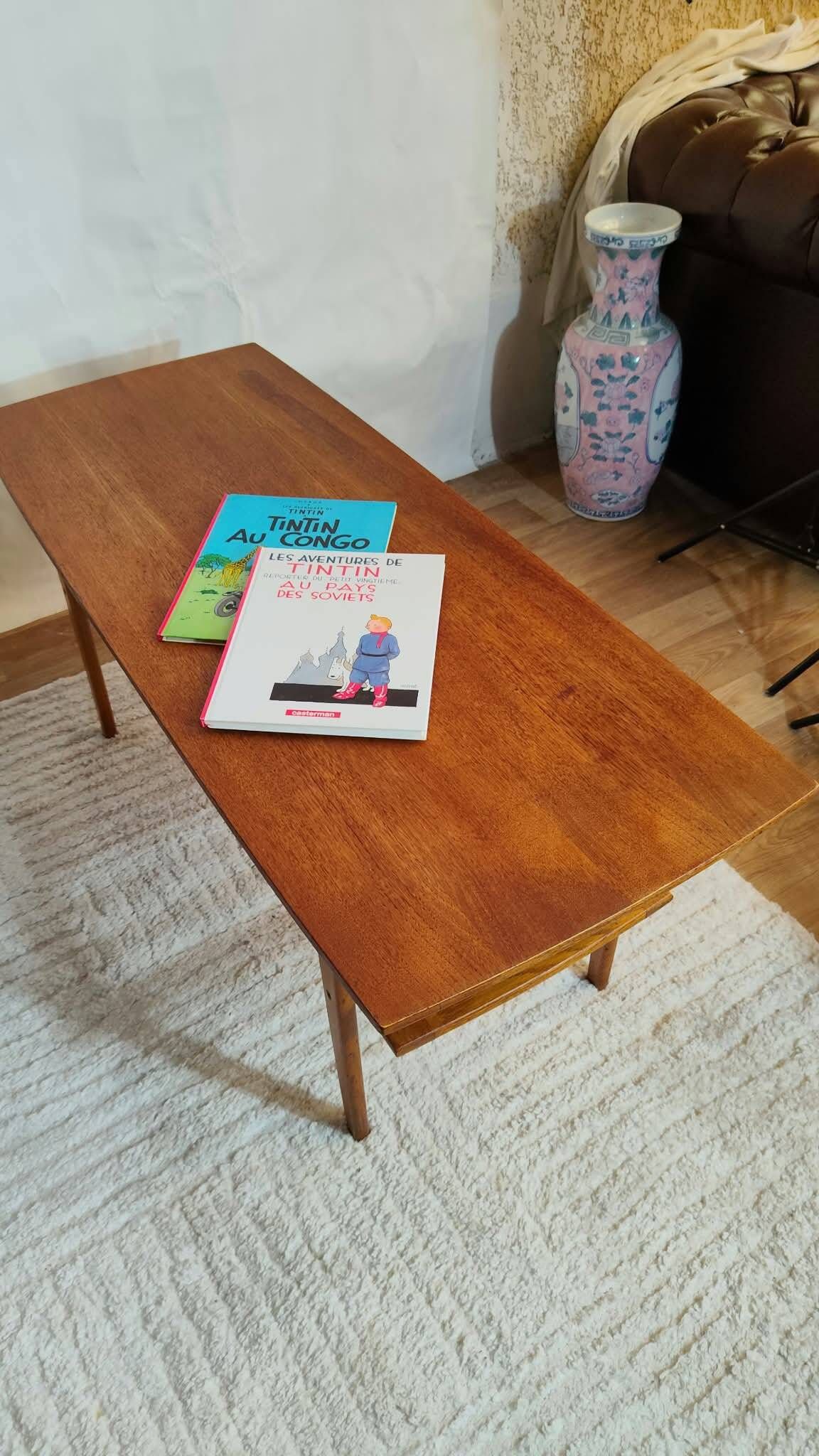Scandinavian coffee table in teak with a lower shelf and brass bars.