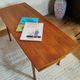 Scandinavian coffee table in teak with a lower shelf and brass bars.
