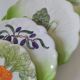 4 hand-decorated earthenware plates with vegetable and green leaf designs.