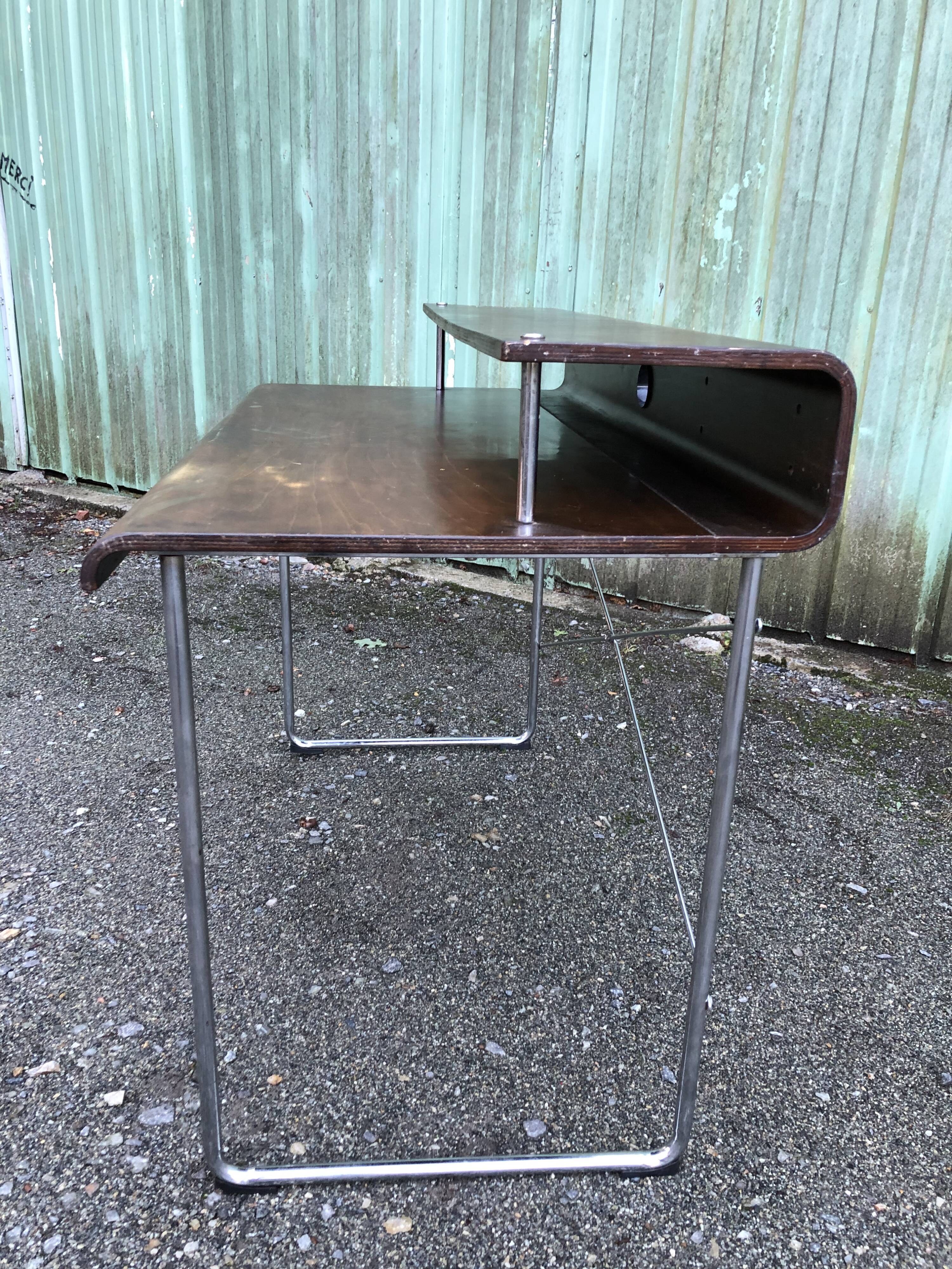 Design desk in formed glued laminated wood with chrome tubular base.