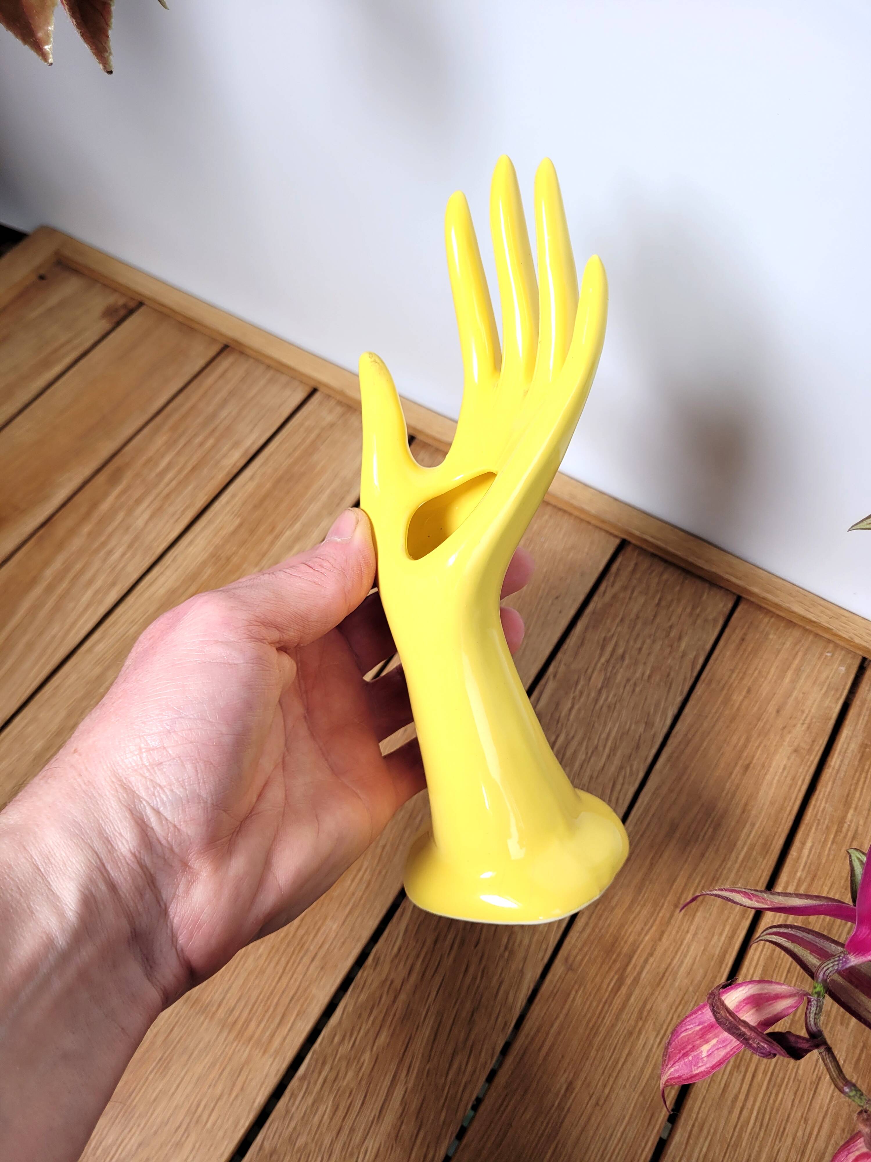 Hand wears ring and yellow soliflore