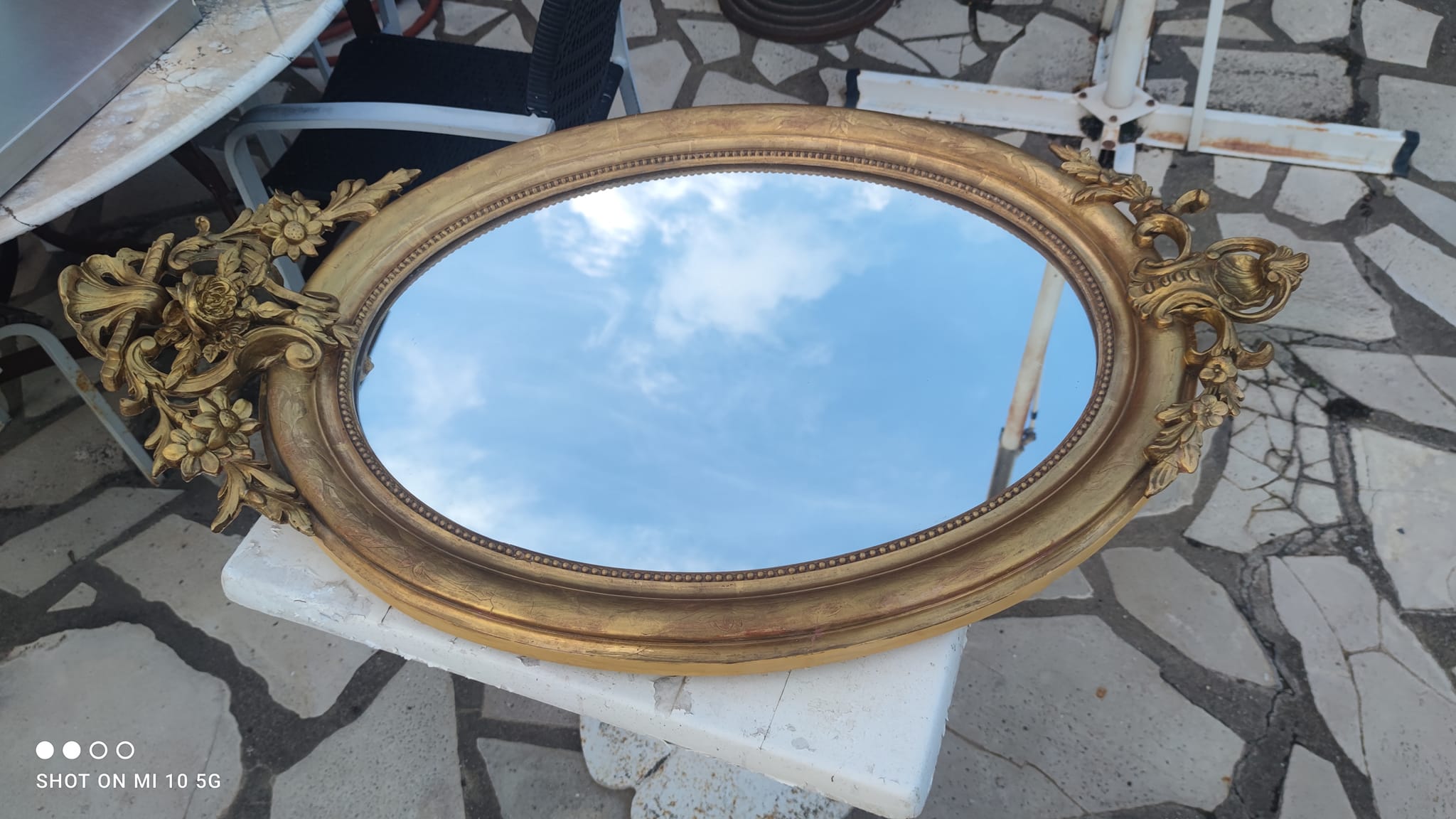 Ovoid mirror with double gilt pediments, circa 1830, 105x66 cm
