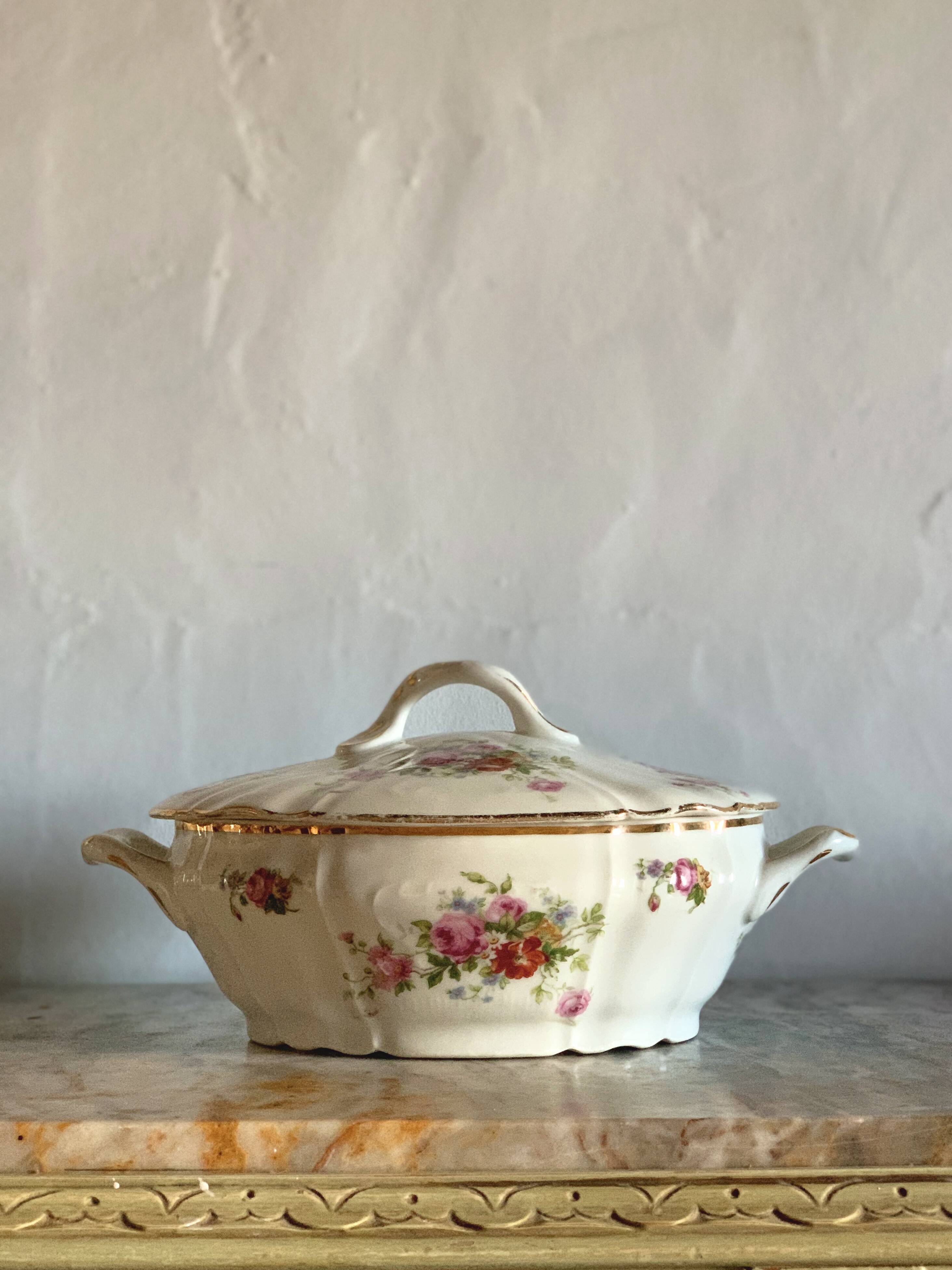 Antique porcelain soup bowl with floral decoration and golden border