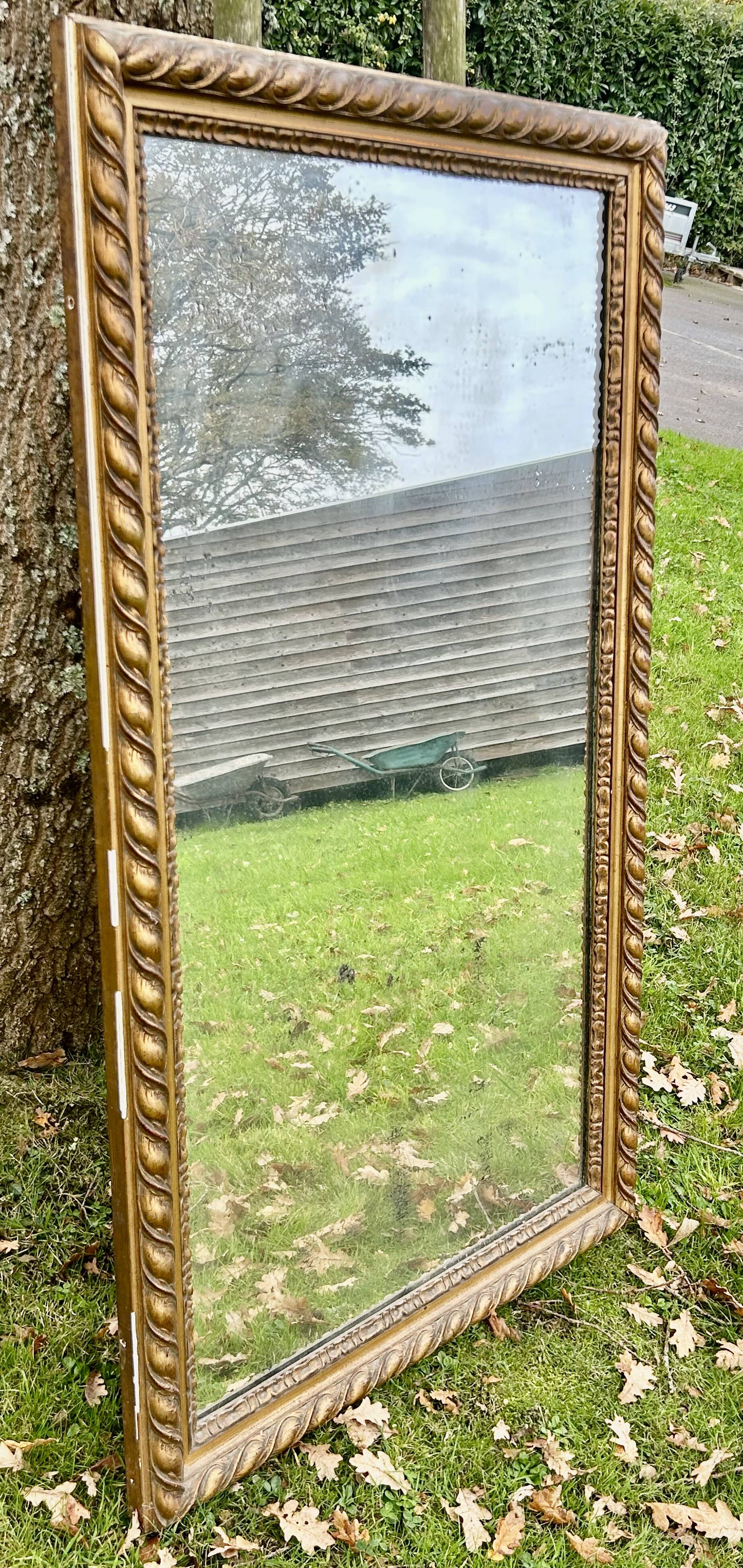 Large antique gilded mirror, wood and stucco gadroons, partially de-mercury