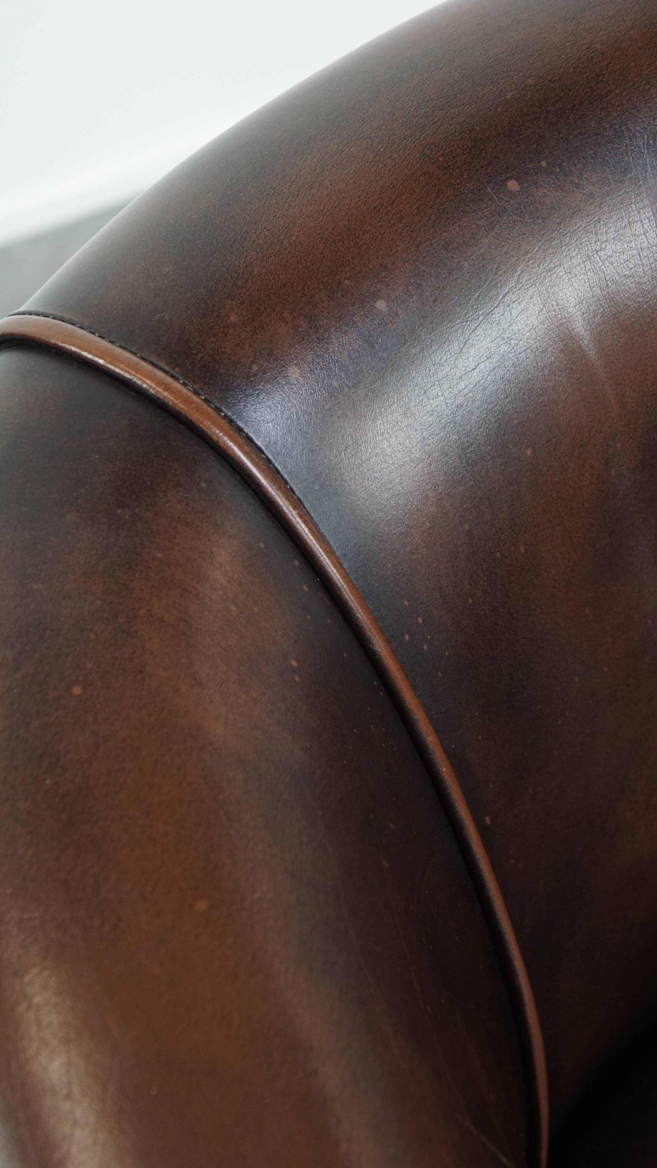 Fauteuil club de couleur foncée en cuir de vachette