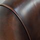 Fauteuil club de couleur foncée en cuir de vachette