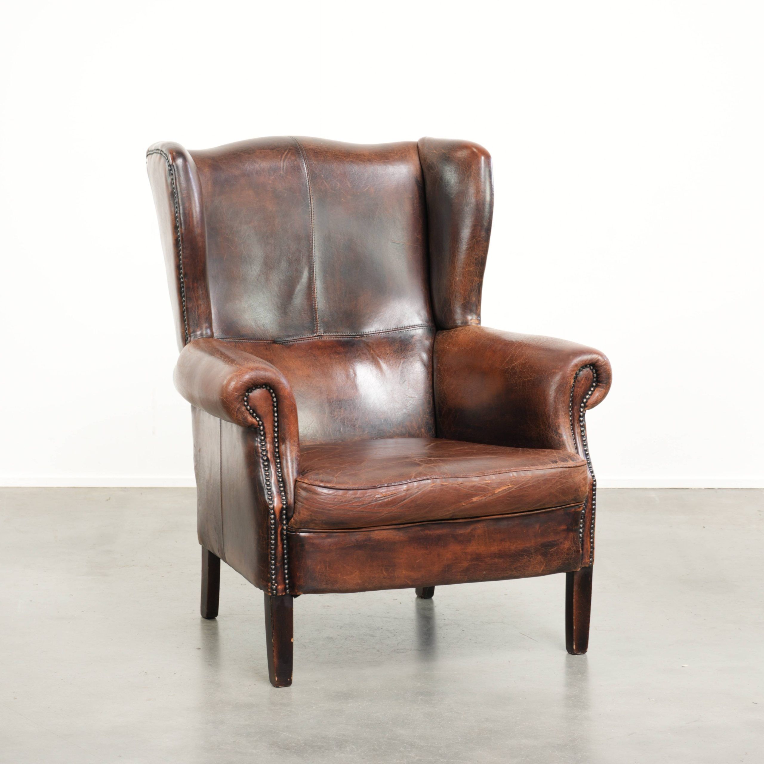 Vintage sheepskin wingback armchair in a deep brown colour finished