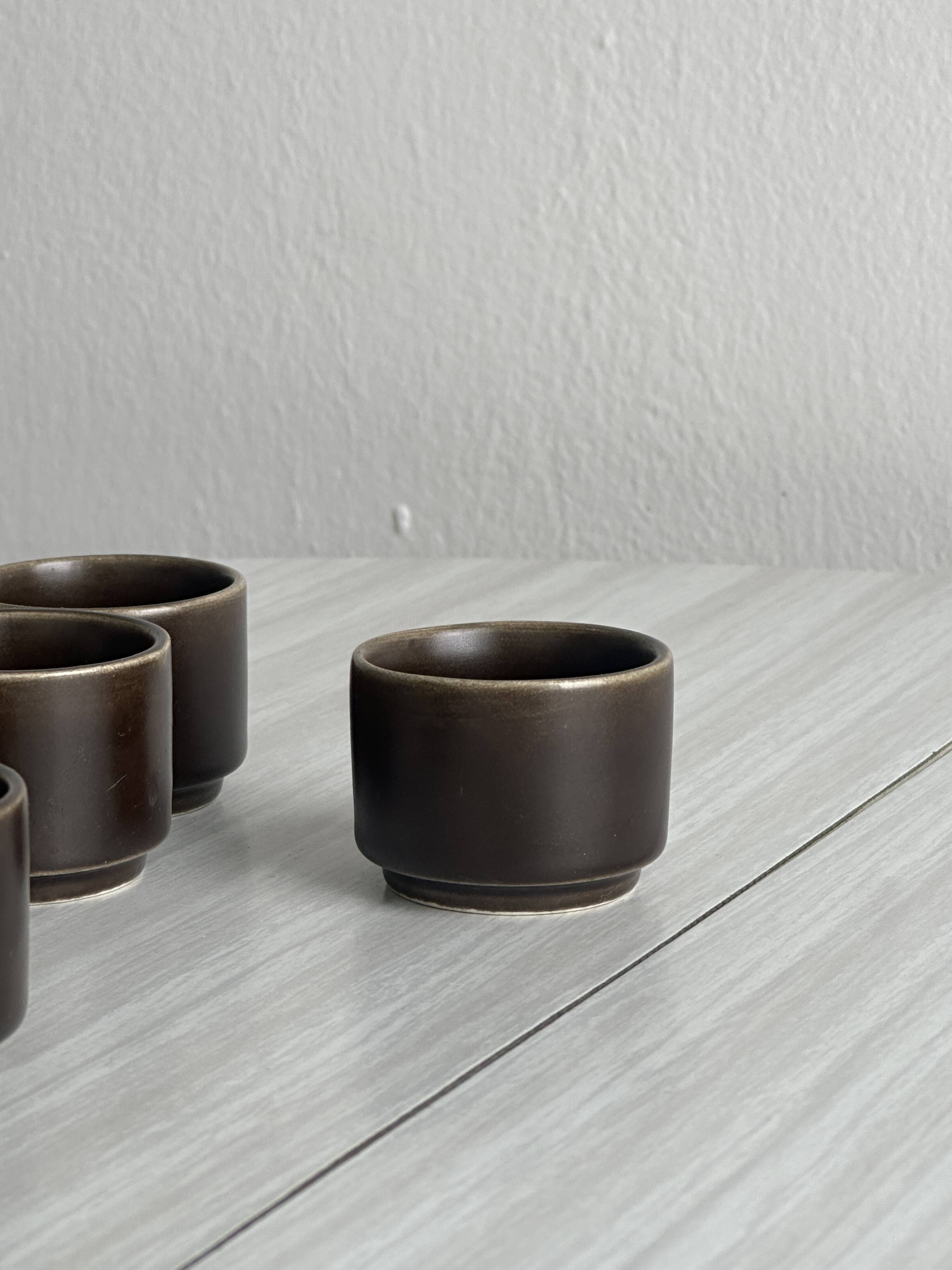 Set of 5 dark brown glazed ceramic egg cups.