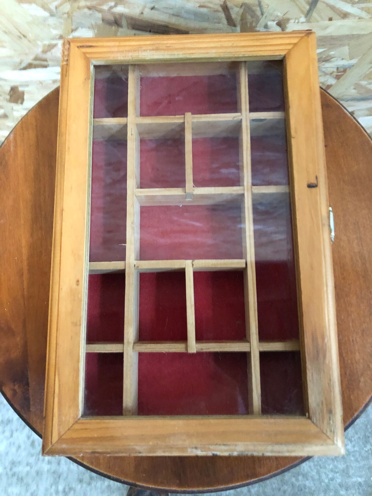 Old hanging display case with 15 wooden boxes, red background + vintage glass door