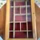 Old hanging display case with 15 wooden boxes, red background + vintage glass door