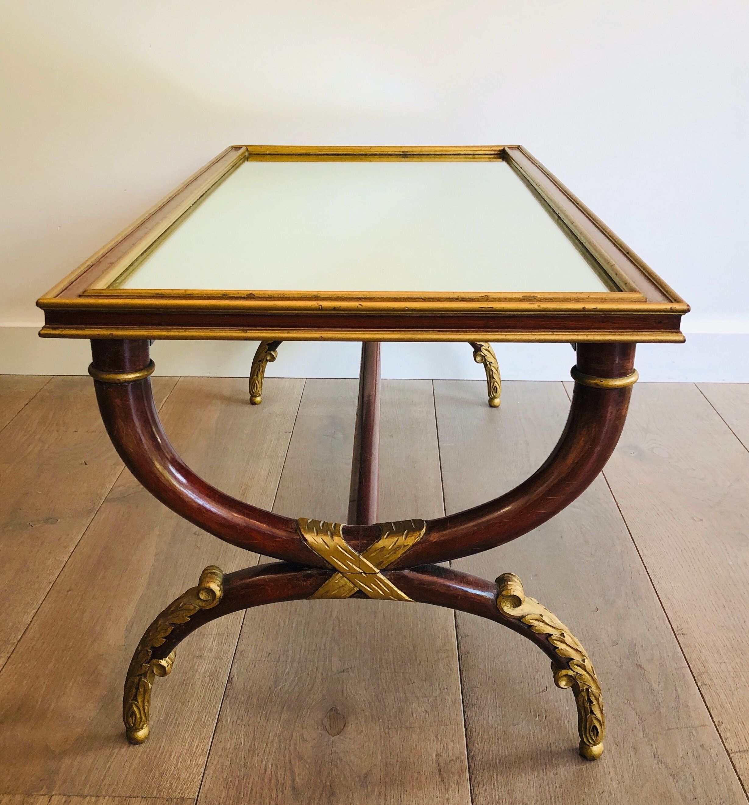 Coffee table in patinated and gilded carved wood with mirror top
