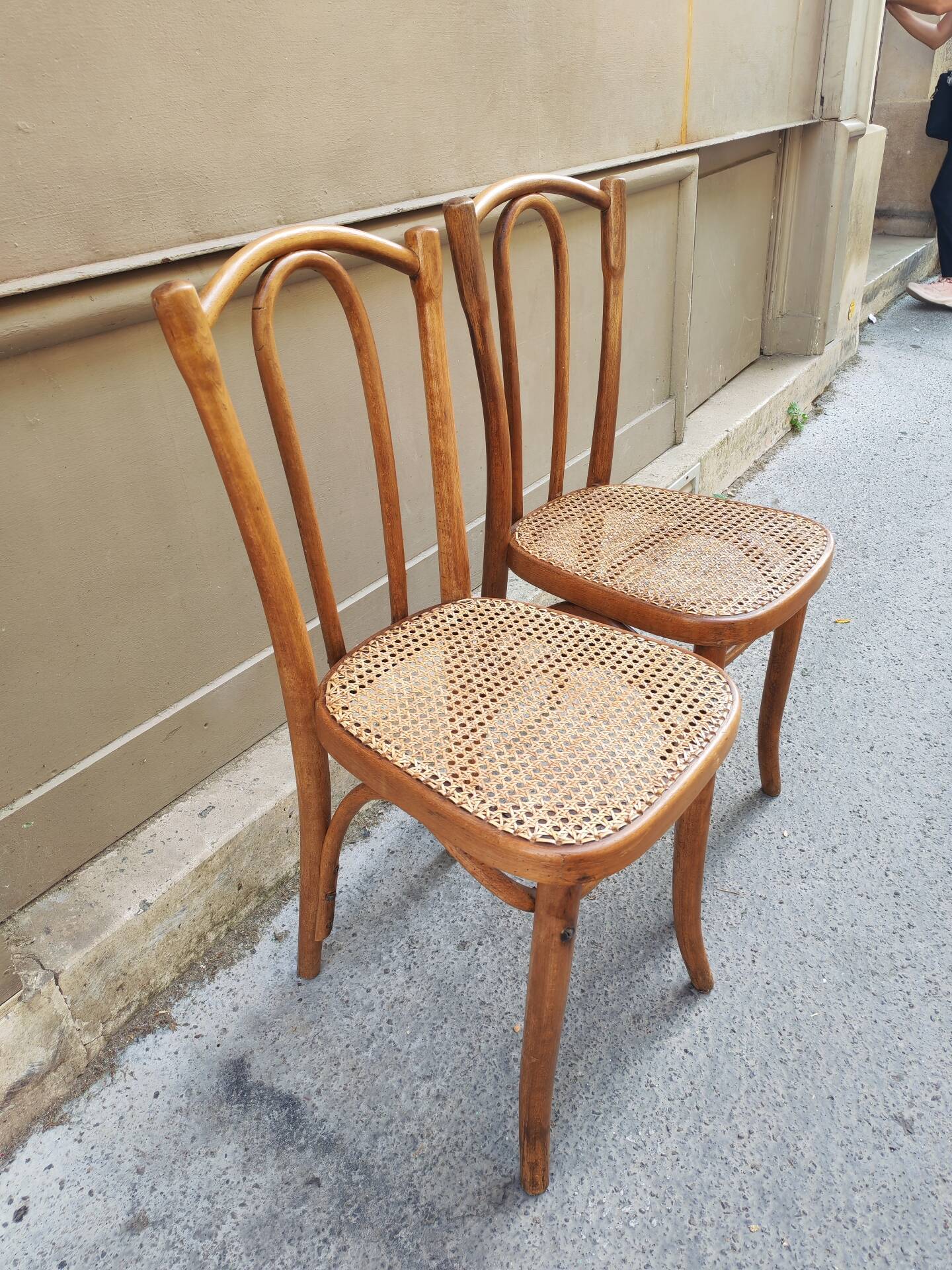 Pair of vintage bistro chairs in curved wood and caning.