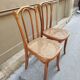 Pair of vintage bistro chairs in curved wood and caning.