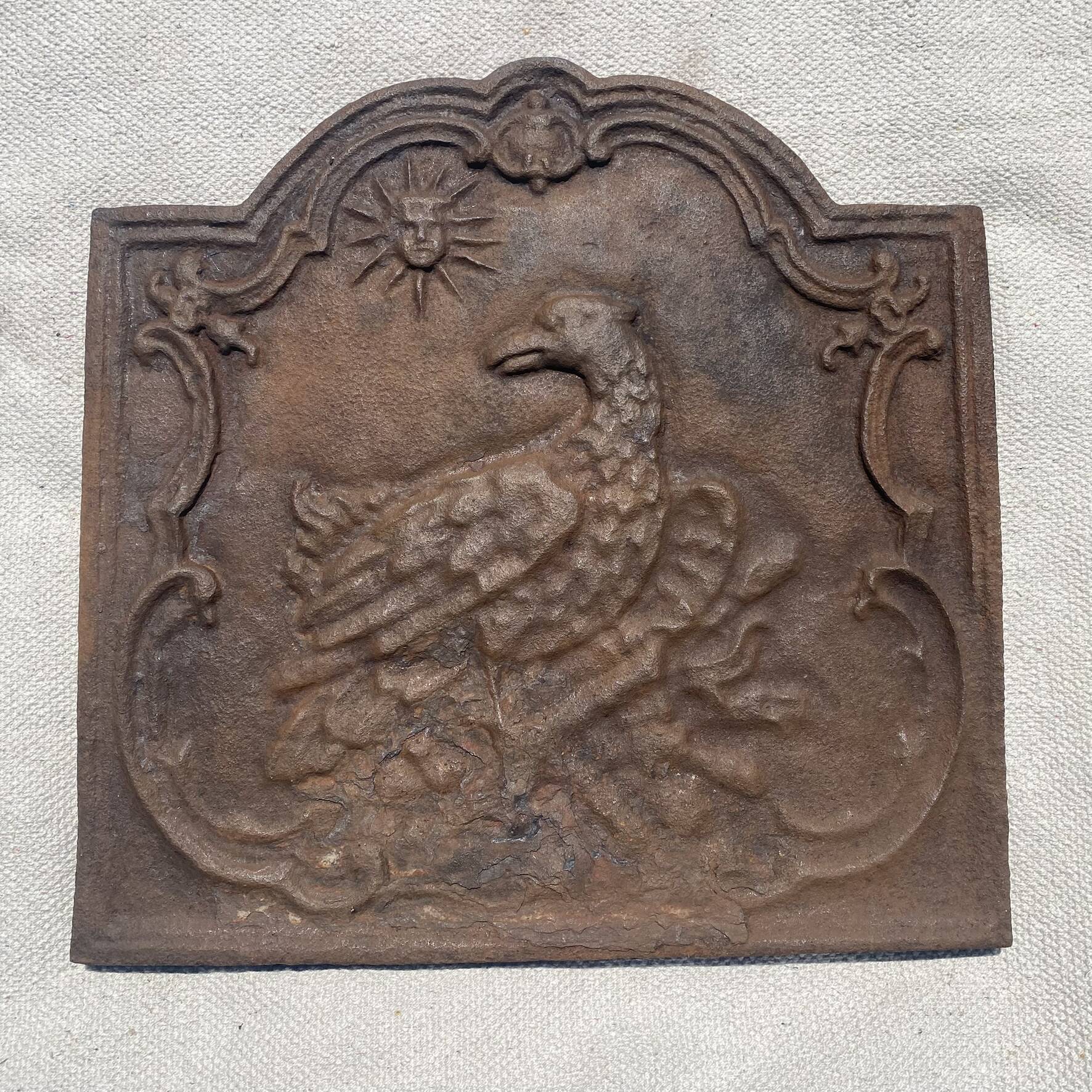 Ancienne plaque de cheminée en fonte ,décor aigle et soleil, 47 × 47 cm