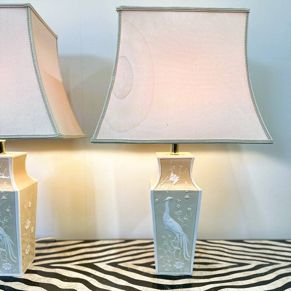 Pair of large cream ceramic table lamps with relief peacocks and fabric shades