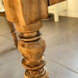 Oval wooden table with drop-leaf edges.