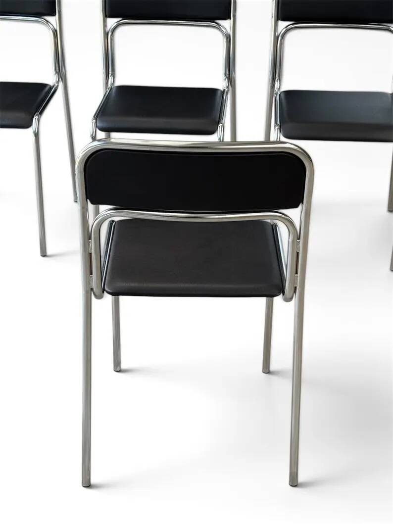 Bauhaus-style tubular steel chairs with black faux leather upholstery, Italian modernist dining room