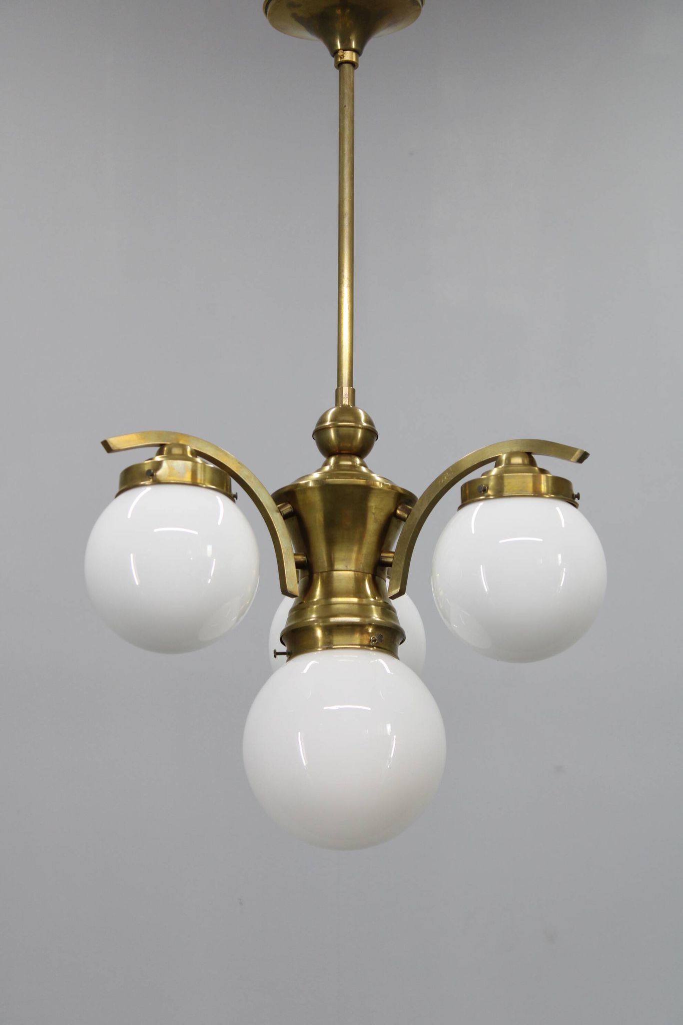 1930s Czechoslovak Art Deco brass chandelier with four opaline glass globes