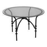 Table à manger vintage avec base tubulaire et plateau en verre avec un nœud.