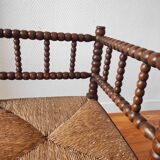 Antique corner chair made of turned wood spindle.