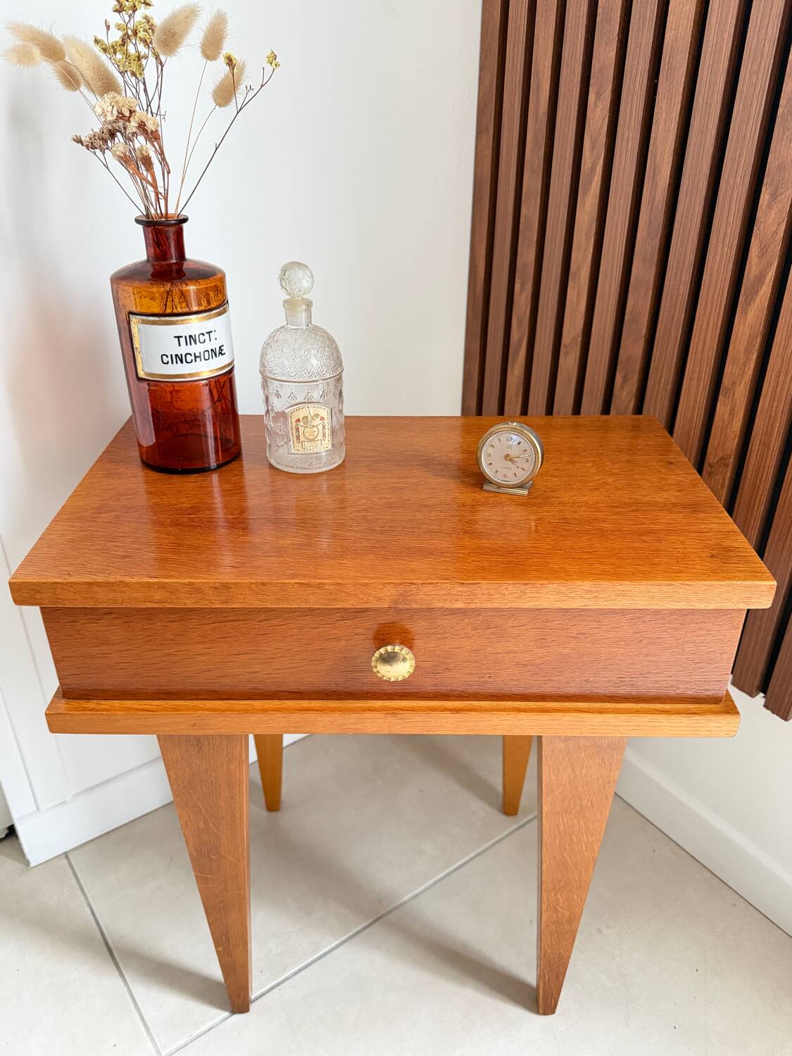 Vintage bedside table with tapered legs.