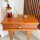 Vintage bedside table with tapered legs.