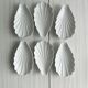 Set of white porcelain ramekins, ribbed shell shape.