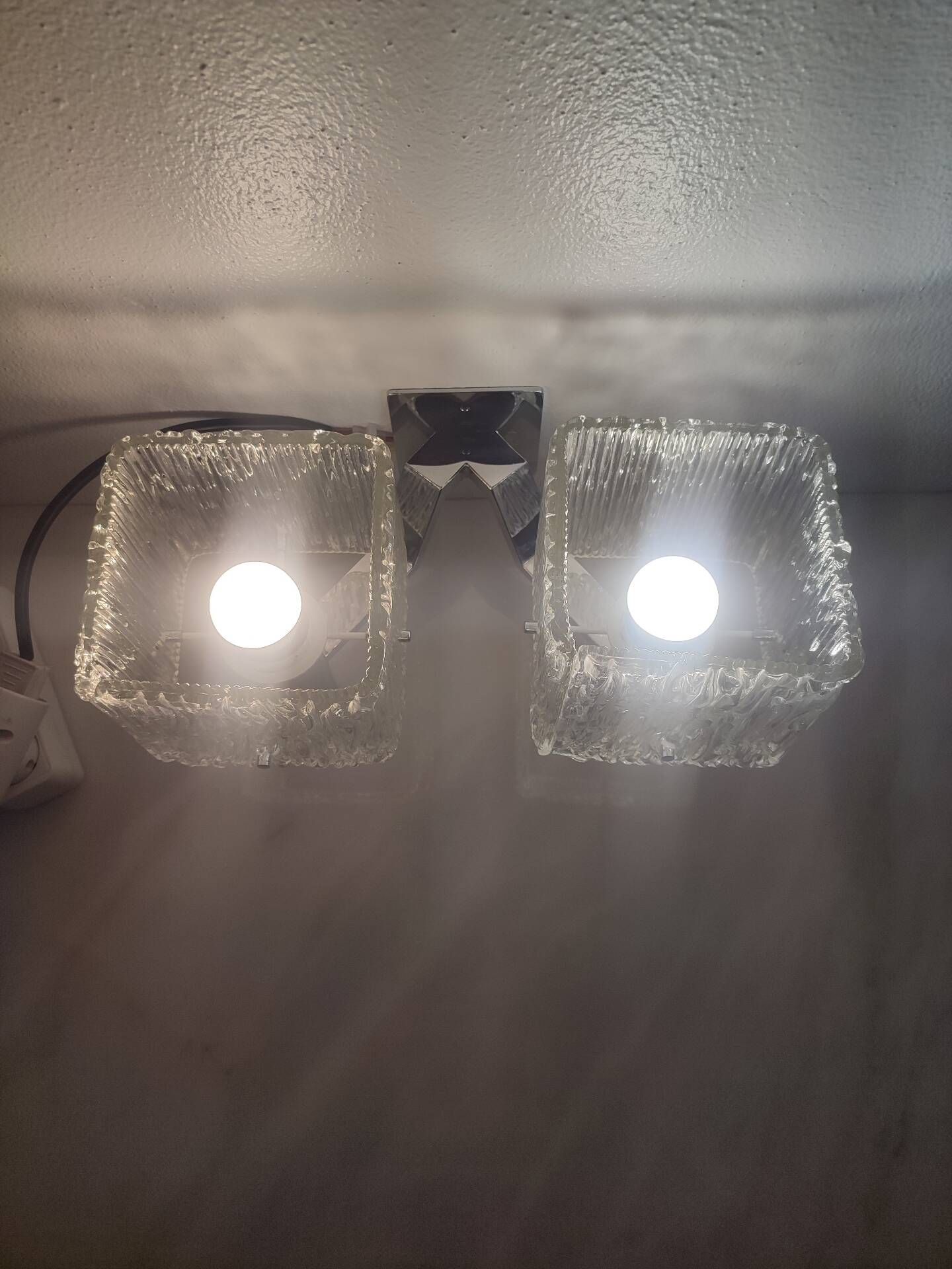 Vintage wall light in textured moulded glass and chrome metal.