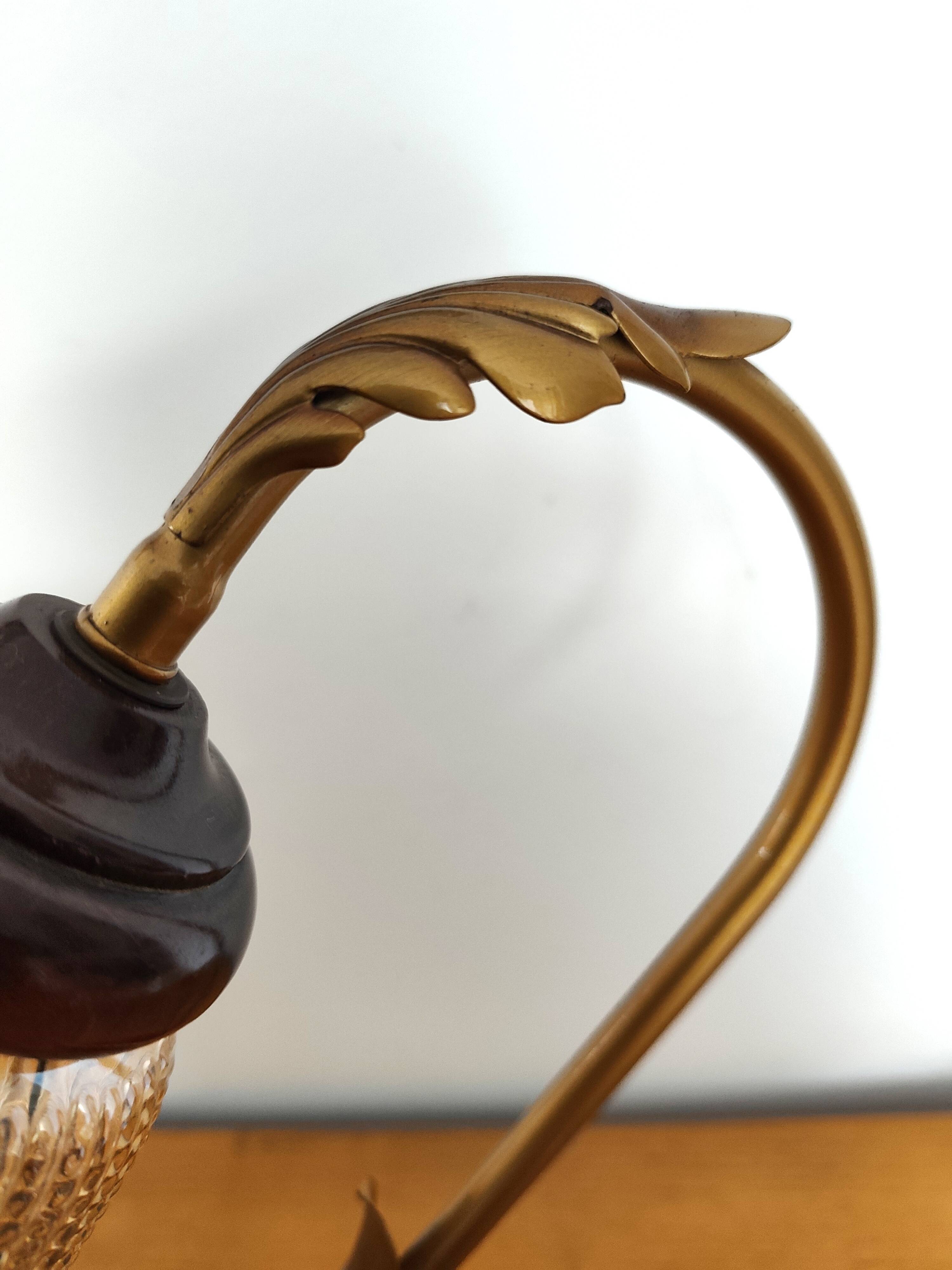 Gold swan neck table lamp with amber tulip glass.