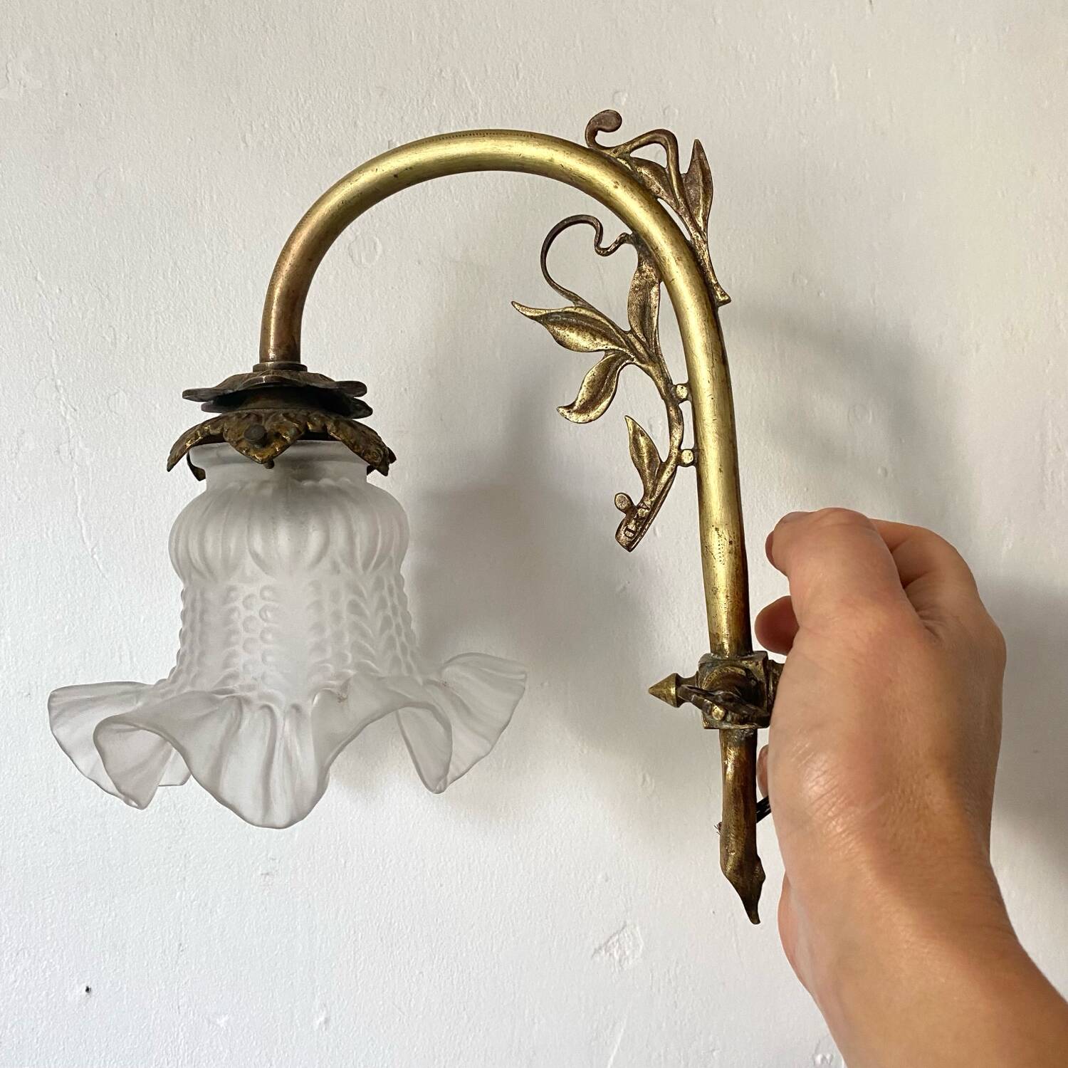 Antique brass wall light with glass shade.