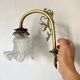 Antique brass wall light with glass shade.