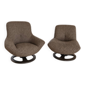 A pair of designer armchairs.
