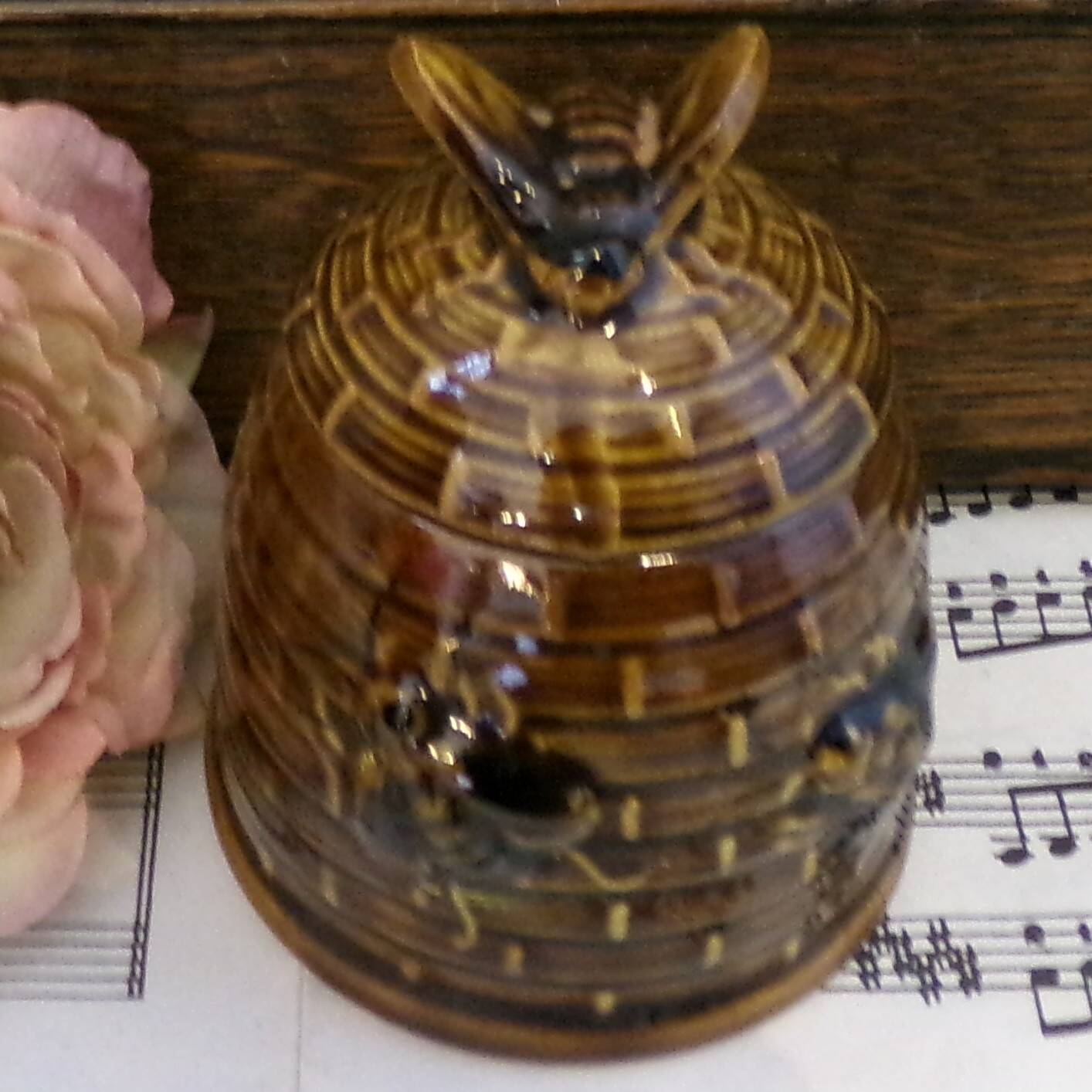 Honey pot in the shape of a hive decorated with bees.