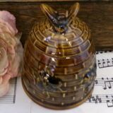 Honey pot in the shape of a hive decorated with bees.