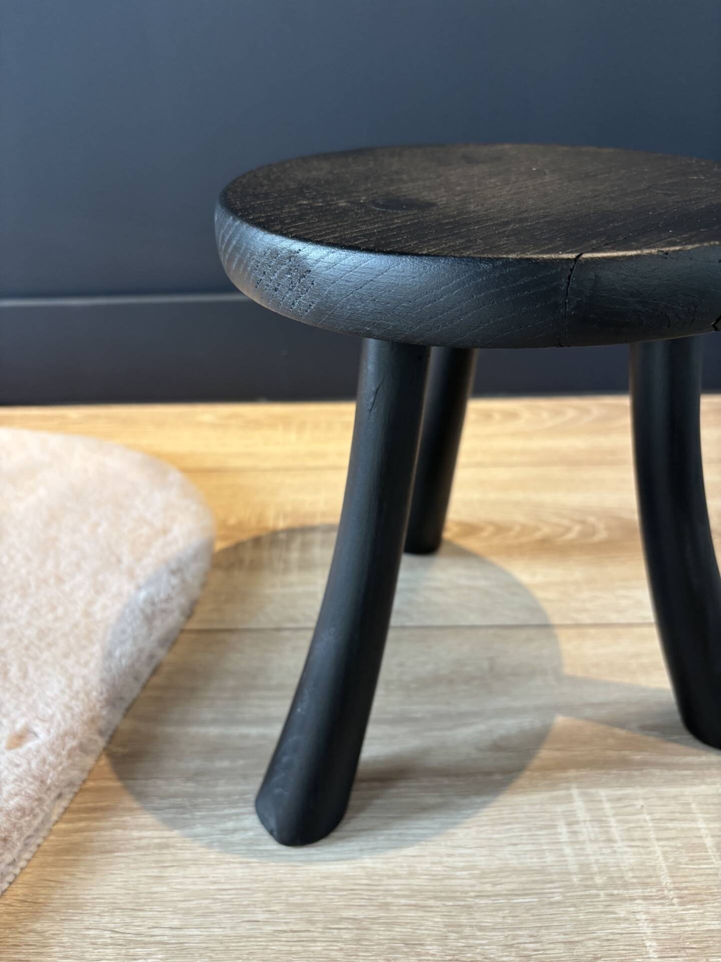 Small black wooden tripod stool